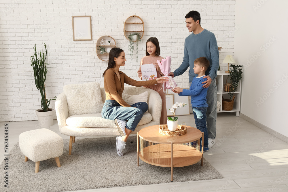 Poster father with children greeting their mother with mothers day with bouquet of tulips, gift and drawing