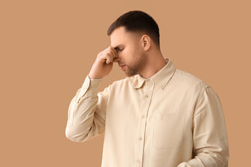 Tired young man on beige background