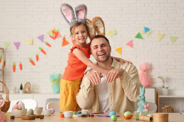 Little girl with her father in Easter bunny ears at home