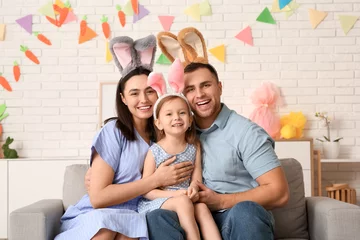 Fotobehang Happy family in Easter bunny ears sitting on sofa at home © Pixel-Shot