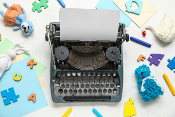 Composition with vintage typewriter, knitted toys and paper on white background