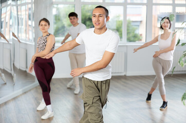 Fototapeta premium Group of young guys and girls dancing jazz funk in the studio