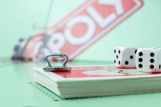 Kaunas, Lithuania - July 2021: close up of monopoly iron token, monopoly board and dices on the monopoly chance cards.