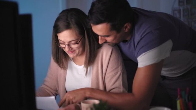 A couple sitting by the computer and working on personal finance at home

