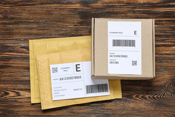 Cardboard package and envelopes with labels on wooden table