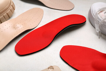 Shoes and orthopedic insoles on white background