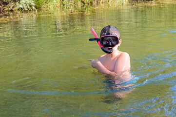 Boy in a mask diving in the water