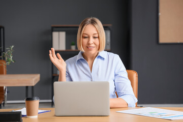 Mature businesswoman working with laptop in modern office