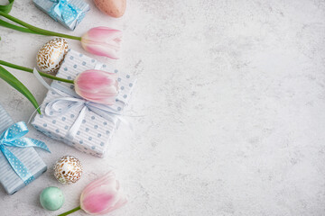 Fototapeta na wymiar Painted Easter eggs with gift boxes and tulip flowers on white grunge background