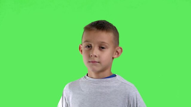 Portrait of a smiling boy with a green screen in the background


