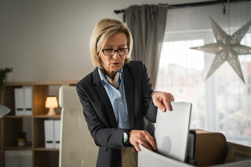 Mature woman lost her job fired from work pack personal items in box