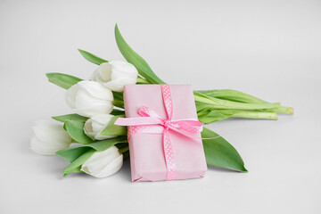 Gift box with tulip flowers on white background