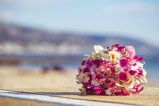 Hawaiian themed orchid bridal bouquet with sandy ocean beach background