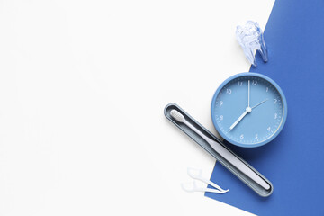Clock, dental floss and toothbrush on color background