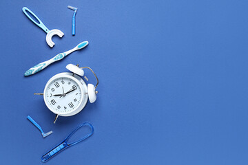 Alarm clock and set for oral hygiene on blue background