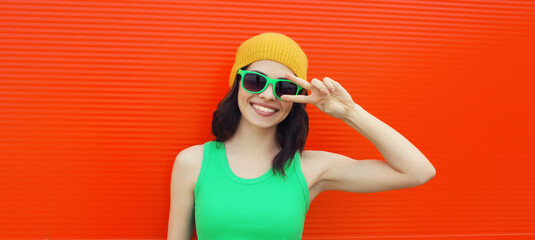 Summer portrait of happy smiling brunette young woman posing in yellow hat, green sunglasses
