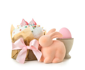 Tasty Easter cake, toy bunny and holder with egg on white background