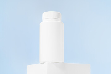 White mockup of a jar of pills or tablets on a blue isolated background. The concept of dietary supplements for men's health, pharmacy, vitamins. Image for your design
