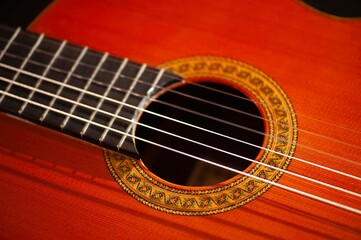 Fototapeta premium Classical Spanish flamenco guitar close up, dramatically lit isolated on black background with copy space.