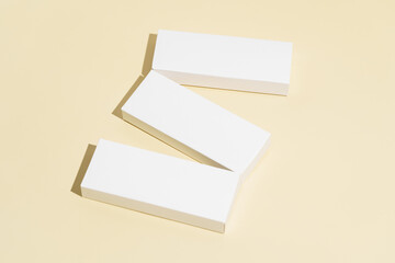 Three white mockup boxes for medicine in blister packs, oral contraceptives or dietary supplements on a yellow isolated background. The concept of pharmacy, health and treatment of diseases