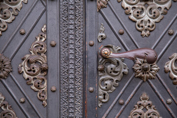 old antique Vintage ancient Door Handle. medieval restored entrance reinforced with decorative metal plates.