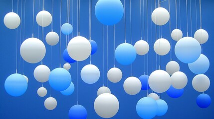  a group of blue and white balls hanging from a blue ceiling with white and blue balls hanging from the ceiling.