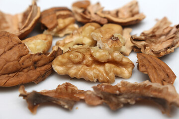 cracked walnut. scattered walnut shells. fruit with hard skin.