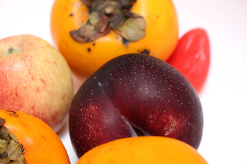 fruit set with persimmon, plum, apple and pepper. fruits with selective focus. colorful foods. colorful fruits.