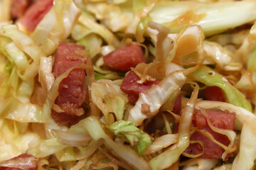 cabbage with sausage. green food with pork. cabbage and sausage with selective focus. meal details.