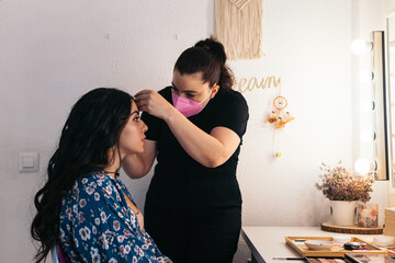 Bride being made up by a professional makeup artist