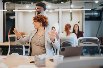 A happy businesswoman celebrates a victory in the office. She sits, smiles, and achieves positive results. She successfully finishes work, demonstrating business achievements.