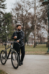 Stylish male entrepreneur enjoys remote work in a serene city park with his bike and coffee.