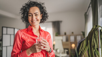 Portrait of one adult mature woman hold glass of water at home