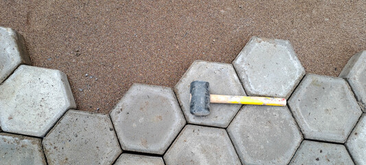 Installation of hexagon paving. Construction tools and details, paving installing with rubber hammer. hexagon paving laying on sand, making of pavement