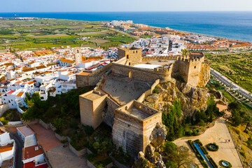Scenic aerial view of Salobrena cityscape and Moorish castle on background with blue water surface of Mediterranean Sea, Spain
