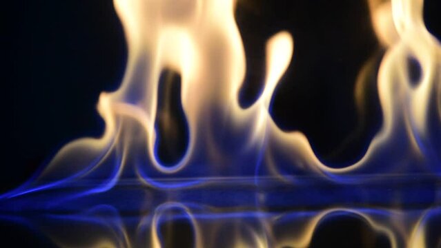 red drink with fire behind and reflection on black background