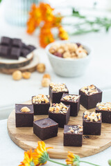 Artisanal Chocolate Fudge Squares with Nuts on Wooden Board, Close-up View