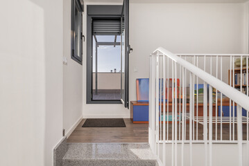Access stairs to a penthouse terrace with gray aluminum doors and windows