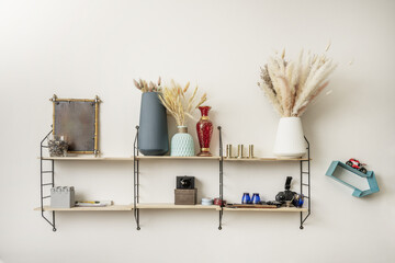 Small wooden shelf with black metal supports full of decorative objects