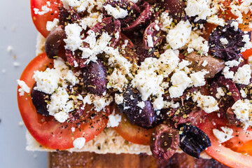 focaccia with fresh tomatoes kalamata olives and feta sprinkled with herbs,