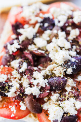 focaccia with fresh tomatoes kalamata olives and feta sprinkled with herbs,