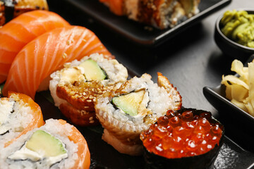 Set of delicious sushi rolls on table, closeup