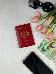 top view of cash money and Malaysia passport as a travel concept