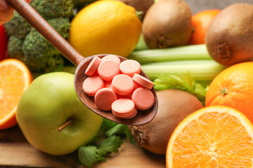 Dietary supplements. Spoon with pills over food products at table, closeup