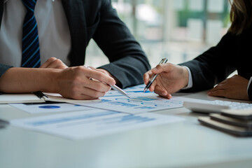 A team of analysts works on a financial data analysis dashboard on paper to use as market indicators for planning, strategic brainstorming, financial investments and marketing new business projects.