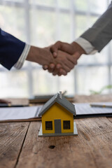 Close-up photo of architect and construction engineer holding hands while working for teamwork and...