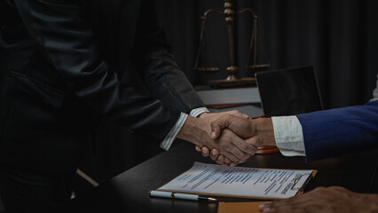 Law and justice concept, businessman shaking hands with lawyer to seal agreement with lawyer, partner or lawyer discussing contract agreement The concept of holding hands. Close-up. - obrazy, fototapety, plakaty