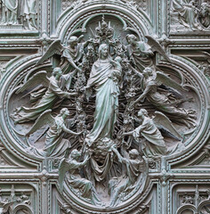 MILAN, ITALY - SEPTEMBER 16, 2024: The detail from main bronze gate of the Cathedral -   Virgin Mary with the angels by Ludovico Pogliaghi (1906). - 767517707