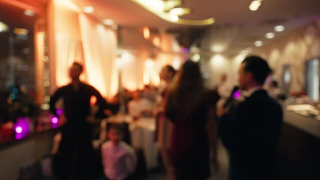 Blurred image of crowd at fun event in magenta decorated room at party