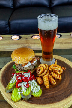 Gourmet Grilled burger with bacon and gorgonzola cheese on a brioche bun with beer